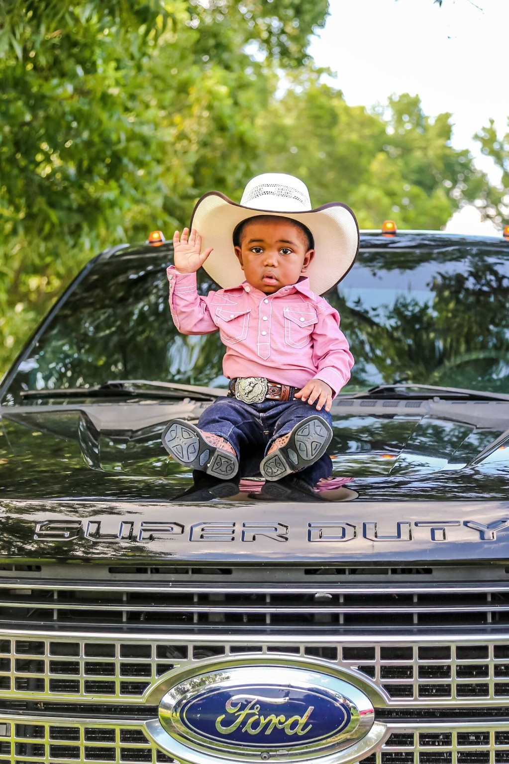 Baby cowboy portrait on truck