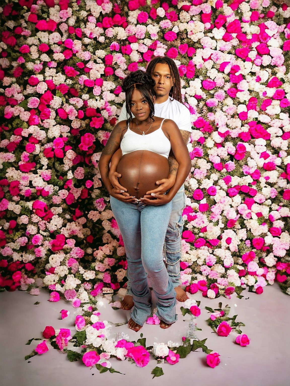 Maternity couple in front of floral wall