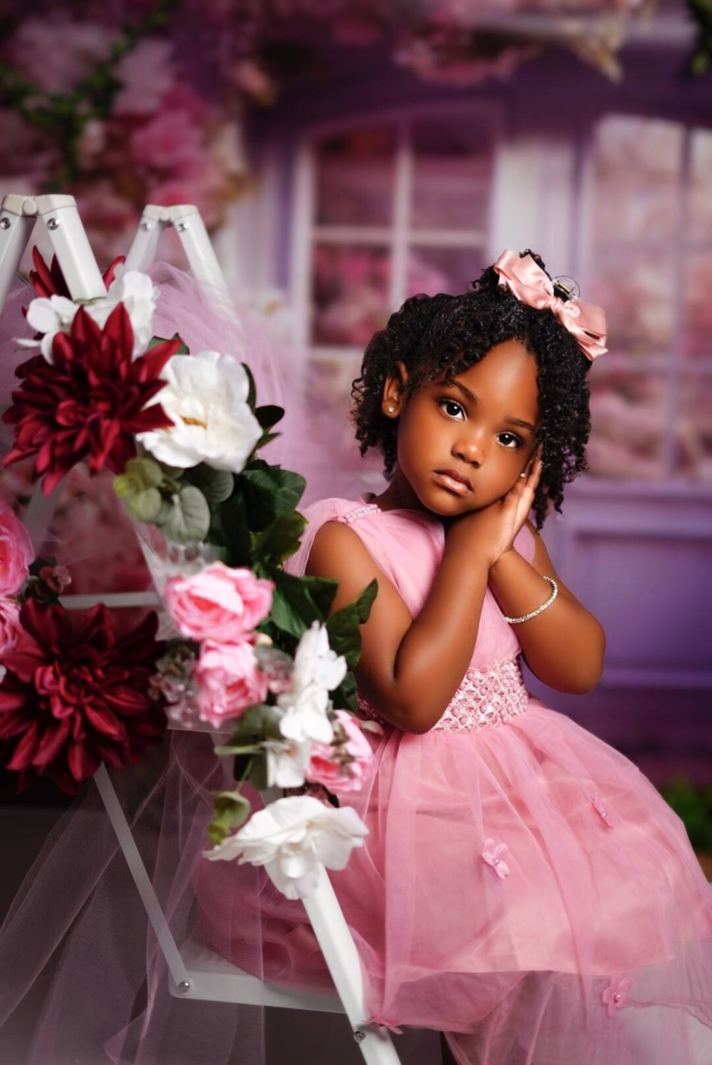 Little girl in pink dress surrounded by flowers